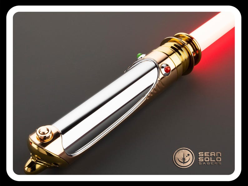 May include: A lightsaber with a polished silver and gold hilt, featuring a red glowing blade. The hilt has a detailed design with a red and green button. The Sean Solo Sabers logo is visible in the bottom right corner.