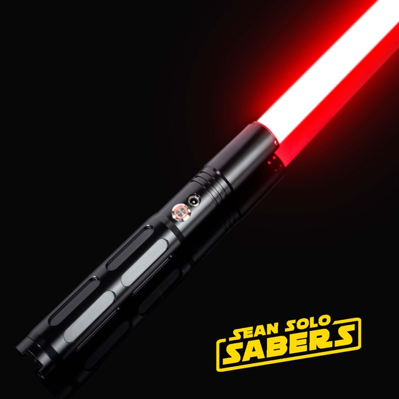 Pu&ograve; includere: Una spada laser nera con una lama rossa. La spada laser ha un'impugnatura testurizzata e un pulsante argentato. La lama &egrave; accesa e si estende dall'impugnatura. Il testo "SEAN SOLO SABERS" &egrave; visibile nell'angolo in basso a destra dell'immagine.