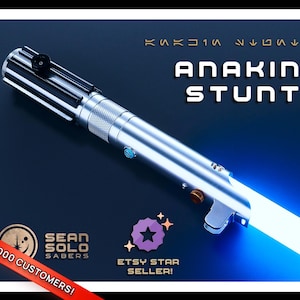 Könnte beinhalten: Ein silbernes und schwarzes "Anakin Stunt" Lichtschwert mit einer leuchtenden blauen Klinge. Das Bild enthält den Text "Sean Solo Sabers" und "Etsy Star Seller!" auf einem dunkelblauen Hintergrund.