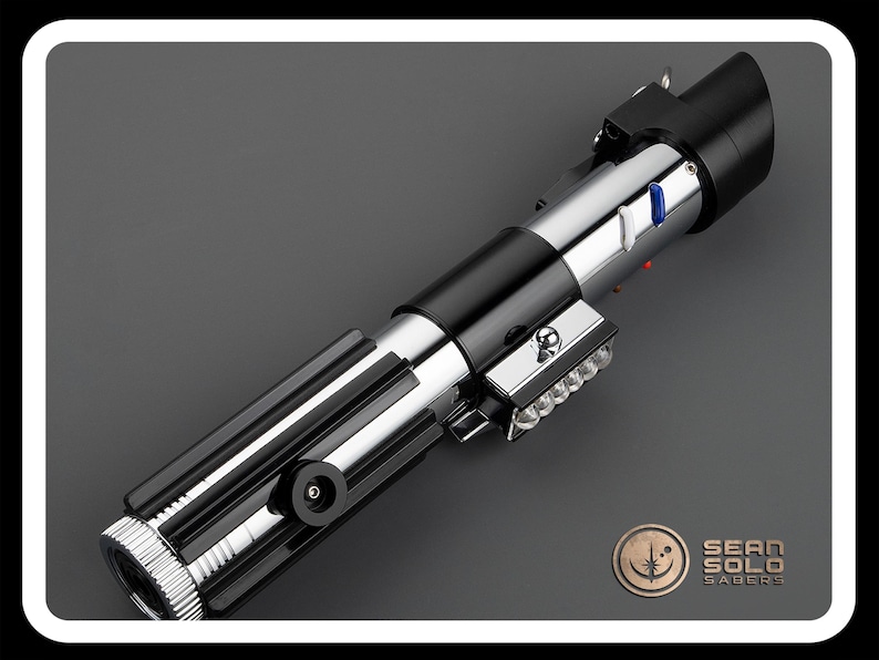 Op de afbeelding: Een zwart en zilveren lightsaber met een blauw en rood licht op de handgreep. De lightsaber is een replica van die gebruikt door Luke Skywalker in de Star Wars-films.
