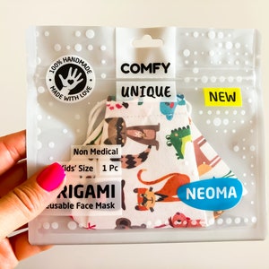 Può includere: Una confezione di plastica trasparente contenente una mascherina riutilizzabile con una colorata stampa animalier. La confezione riporta le parole "COMFY", "UNIQUE" e "NEW". La mascherina è etichettata "Kids' Size" e "Non Medical".