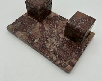 May include: A marble desk set with two square inkwells. The set is made of brown and pink marble with a swirling pattern.