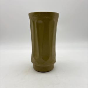 May include: A tall, olive-green ceramic vase with a slightly flared top and a textured surface. The vase has vertical grooves and a rounded base. The neutral color and simple design make it suitable for various decor styles.