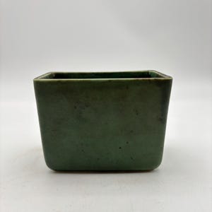 May include: A set of three ceramic mugs with a speckled, matte finish. The mugs are in shades of cream, light gray, and dark gray. Each mug has a simple, minimalist design and a rounded handle. Perfect for coffee or tea.