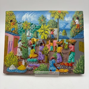 May include: A colorful painting depicting a bustling marketplace scene. Palm trees, buildings, and figures in various attire are visible. The artwork features a vibrant blue sky and a coastal backdrop, with boats sailing in the distance.