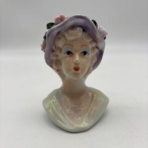 May include: A set of three ceramic mugs with a speckled, matte finish. The mugs are in shades of cream, light brown, and dark brown. Each mug has a simple, minimalist design and a rounded handle.