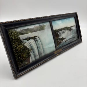 May include: A vintage black framed print featuring two images of Niagara Falls. The frame has a decorative edge and a small plaque with text. The images show the waterfalls with water cascading over the edge.