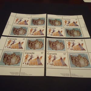 Op de afbeelding: Vier vellen Canadese postzegels. Elke postzegel toont een inheemse Amerikaanse scène met een tipi en figuren, en het nummer 17. De postzegels staan op een witte achtergrond.