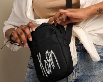 Crossbodytas Korn: nu-metalen grunge draagriem met witte print
