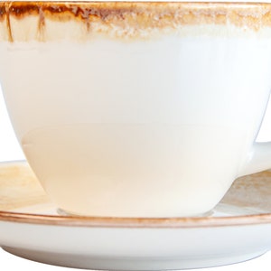 May include: A white ceramic coffee cup with a brown rim and a matching saucer. The cup is empty and the saucer is on a black background.