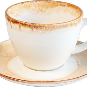 May include: A white ceramic coffee cup with a brown rim and a brown stain around the top. The cup is sitting on a matching saucer.
