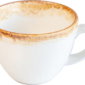 May include: A white ceramic coffee cup with a brown rim and a brown glaze around the top edge. The cup has a rounded shape and a handle.