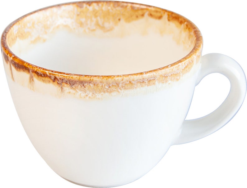 May include: A white ceramic coffee cup with a brown rim and a brown glaze around the top edge. The cup has a rounded shape and a handle.