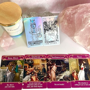 Può includere: Carte dei tarocchi con varie illustrazioni e testo, tra cui "Ace of Cups" e "The Lovers". Le carte sono disposte con una candela, una stella di quarzo rosa e un grande cristallo di quarzo rosa.