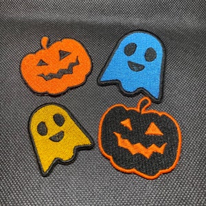 Könnte beinhalten: Vier Halloween-bügelbilder: zwei orangefarbene Kürbisse mit schwarzen Augen und Mündern, ein blauer Geist mit schwarzen Augen und einem Lächeln und ein gelber Geist mit schwarzen Augen und einem Lächeln.
