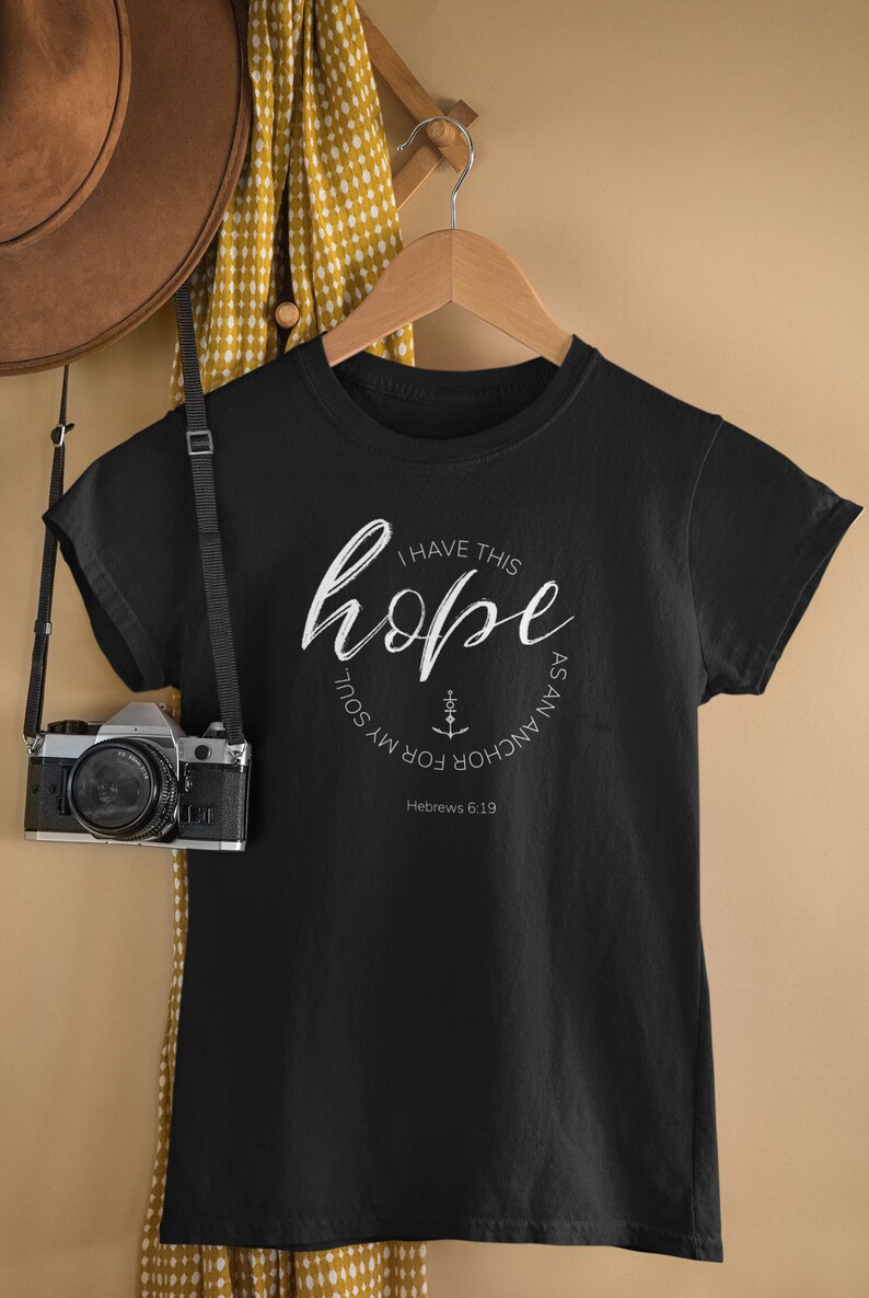 May include: Black t-shirt with a white circle graphic that says "I have this hope as an anchor for my soul" with an anchor symbol and the text "Hebrews 6:19".