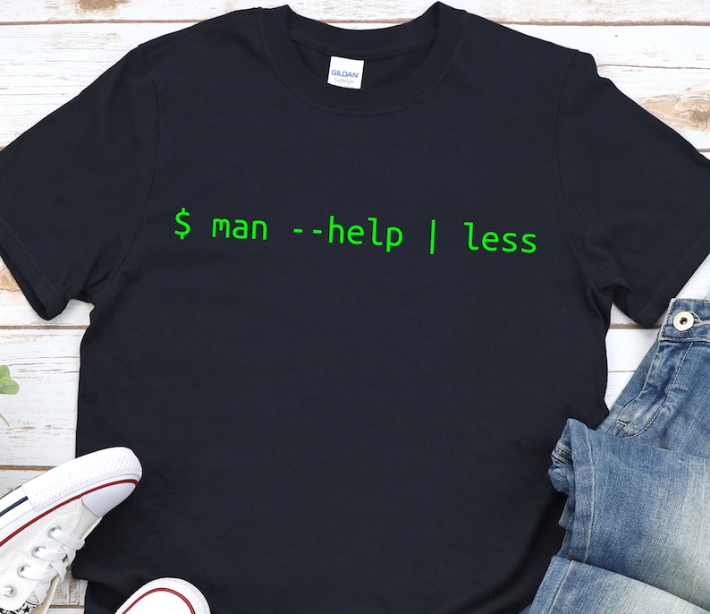 May include: A black t-shirt with green text that reads "$ man --help | less".