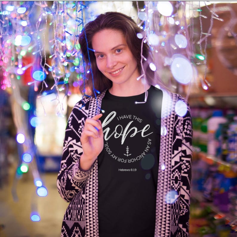 May include: A black t-shirt with a white circle graphic that says "I have this hope as an anchor for my soul" with a small anchor symbol and the scripture reference "Hebrews 6:19".