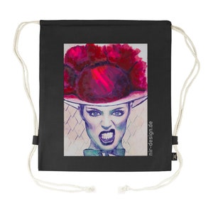 Puede incluir: Bolsa de cordón negra con una ilustración colorida de una persona que lleva un gran sombrero rojo y una expresión feroz. El texto "nir-design.de" está impreso en la bolsa.