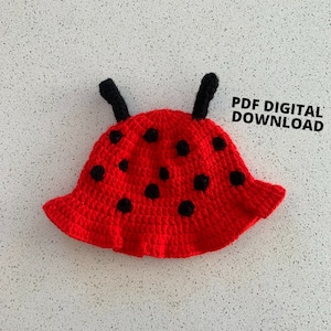 Può includere: Cappello da coccinella in crochet rosso con punti neri e antenne. Il testo 'PDF DIGITAL DOWNLOAD' è visibile nell'immagine.