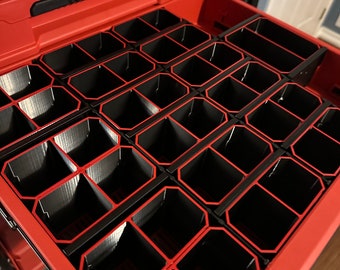 May include: A red Milwaukee Packout toolbox with a drawer open, revealing a black organizer with multiple compartments. The organizer is designed to hold small tools and accessories.