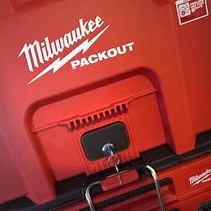 May include: Red Milwaukee Packout toolbox with a black lock and key. The box has a white logo with the text "Milwaukee Packout".