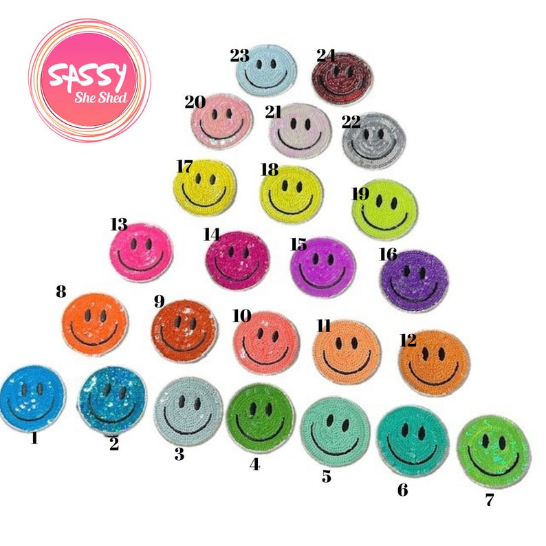 May include: Twenty-four colourful smiley face iron-on patches with sequins. The patches are arranged in a circle with numbers 1 through 24 around the outside.