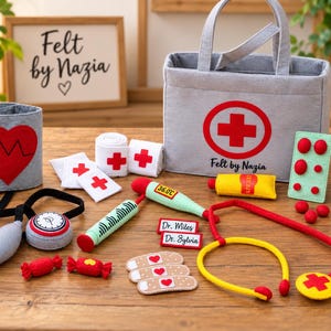 Może przedstawiać: Zestaw lekarski z filcu zawierający szarą torbę medyczną z czerwonym krzyżem i napisem Felt by Nazia. Zawiera ciśnieniomierz, stetoskop, termometr wskazujący 36.0C, strzykawkę, butelkę z lekarstwem, plastry, tabletki oraz dwie plakietki z imionami Dr. Miles i Dr. Sylvia.