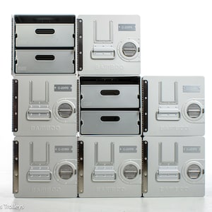 Può includere: Una pila di contenitori in metallo argentato con cassetti e punti di accesso circolari. La parola "BAMBOO" è stampata sulla parte anteriore dei contenitori. Ogni contenitore reca la scritta "C-23170".