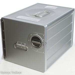 Könnte beinhalten: Eine silberne Aluminium-Aufbewahrungsbox mit einem Griff oben und einem kleineren Griff an der Seite. Die Box hat eine strukturierte Oberfläche und ist aus strapazierfähigem Material gefertigt.