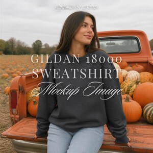 May include: A dark charcoal gray crewneck sweatshirt with long sleeves. The image features the text GILDAN 18000 SWEATSHIRT Mockup Image and millennium dream design overlaid on the scene of a person in a pumpkin patch with an orange truck.