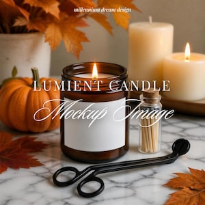 May include: A brown glass candle jar with a white label, a lit wick, and a black metal wick trimmer. Beside it sits a small glass bottle filled with wooden matches, two cream-colored pillar candles, an orange pumpkin, and autumn leaves.