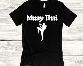 May include: Black t-shirt with white text that says "Muay Thai" and a silhouette of a person in a fighting stance.