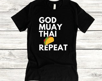 May include: Black t-shirt with white text that reads "God Muay Thai Repeat" and a cartoon taco graphic.