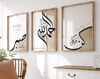 May include: Three framed prints featuring Arabic calligraphy in black ink on a white background. The prints are hung on a white wall. The left print reads "Sabr" in Arabic, the middle print reads "Alhamdulillah" in Arabic, and the right print reads "Insha'Allah" in Arabic.