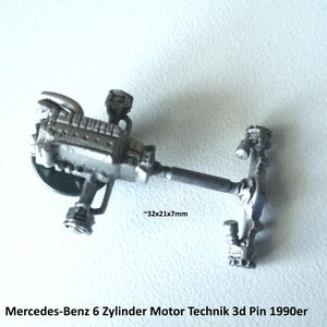 Può includere: Un pin 3D in argento che rappresenta un motore Mercedes-Benz a 6 cilindri con tecnologia motore degli anni '90. Il pin è lungo circa 3,2 cm, largo 2,1 cm e spesso 0,7 cm. Il pin è una replica dettagliata di un motore di auto.
