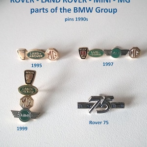 Op de afbeelding: Vier vintage emaille-speldjes met de logo's van Rover, Land Rover, Mini en MG. De speldjes zijn goudkleurig met groene en rode accenten. De tekst "Rover - Land Rover - Mini - MG parts of the BMW Group pins 1990s" is boven de speldjes gedrukt.