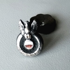 Peut inclure: Épinglette en argent avec un design d'aigle noir et blanc et le texte "Automobilklub" autour du bord.