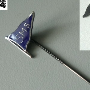 Könnte beinhalten: Eine silberne Emaille-Anstecknadel mit einer blauen Flagge, auf der "SMS" steht. Die Nadel ist ein Vintage-Artikel aus den 1950er Jahren und ein Sammlerstück für Liebhaber der maritimen Geschichte.