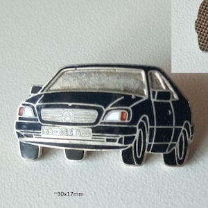 Könnte beinhalten: Schwarze Emaille-Anstecknadel mit einem Mercedes-Benz 600 SEC, ca. 30 mm x 17 mm. Die Anstecknadel zeigt die Front des Autos mit dem Mercedes-Logo und dem Text "600 SEC" auf dem Nummernschild. Der Text "Mercedes-Benz 600 SEC schwarz Pin emailliert 1993" und "Mercedes-Benz 600 SEC black pin enameled 1993" ist ebenfalls sichtbar.