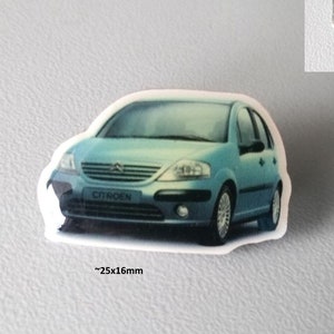 Peut inclure: Un badge épinglette de voiture Citroën C3 bleu, mesurant 25x16mm. Le badge présente une photo de la voiture et le texte "Citroen C3 Pin von IAA 2001".