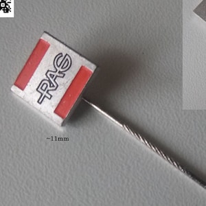 Può includere: Uno spillo d'argento con un logo quadrato rosso e bianco che dice "RAG" e un retro dello spillo in argento. Lo spillo misura circa 11 mm. Lo spillo è etichettato "RAG Ruhrkohle AG Logo Anstecknadel 1990er" e "RAG Ruhrkohle AG logo pin 1990s".