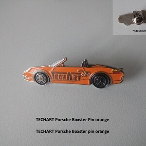 May include: Orange Porsche Boxster car pin with the word "TECHART" printed on the side. The pin is approximately 44mm x 13mm.