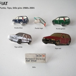 May include: A collection of five enamel pins featuring different Fiat car models. The pins are in various colours, including blue, green, white, and red. The pins feature the Fiat Punto, Tipo, and Stilo models. The pins are arranged in a grid pattern on a white background. The text "FIAT Punto, Tipo, Stilo pins 1980s-2001" is printed above the pins.
