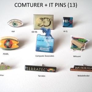 Op de afbeelding: Een verzameling van 13 kleurrijke emaille-pins met verschillende logo's en ontwerpen. De pins bevatten logo's voor bedrijven zoals Sirius, Terratec, Webdefender, Mitsumi, Computer Associates en Pearl. De pins zijn gerangschikt op een wit oppervlak.