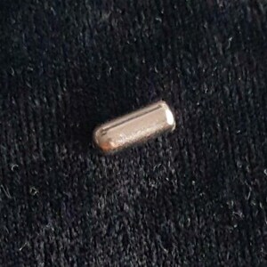 May include: A silver metal cylinder with a smooth, shiny surface.