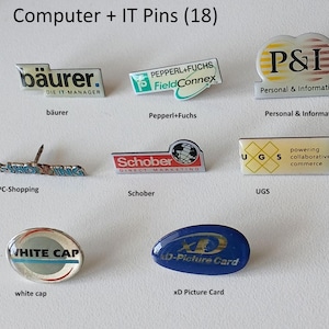 Könnte beinhalten: Eine Sammlung von 10 bunten Emaille-Pins mit Logos verschiedener Computer- und IT-Unternehmen. Die Pins sind in zwei Reihen auf weißem Hintergrund angeordnet. Die Logos beinhalten "baurer. DIE IT-MANAGER", "PEPPERL+FUCHS FieldConnex", "P&I Personal & Informatik", "PC-Shopping", "Schober DIRECT MARKETING", "UGS powering collaborative commerce", "WHITE CAP" und "XD-Picture Card".