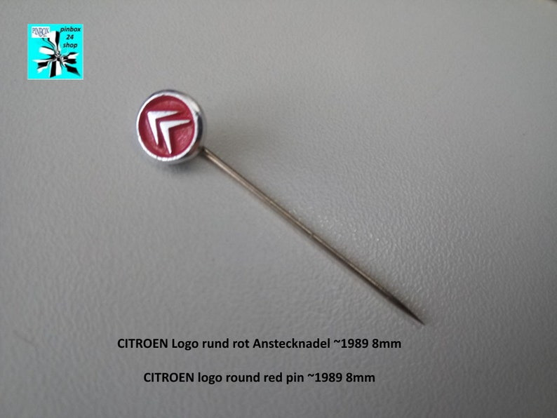 May include: A red and silver pin with the Citroen logo. The pin is round and measures approximately 8 mm in diameter. The text on the pin reads "CITROEN Logo rund rot Anstecknadel ~1989 8mm" and "CITROEN logo round red pin ~1989 8mm".