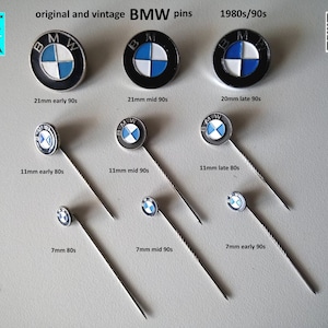 Può includere: Una collezione di spille BMW vintage di diverse dimensioni, che vanno dai 7 mm ai 21 mm. Le spille presentano il logo classico BMW con un design a elica blu e bianco su sfondo nero. Le spille sono disposte in file, con le spille più grandi in alto e le spille più piccole in basso. Le spille sono tutte in buone condizioni e hanno una finitura argentata.