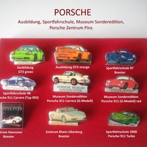 Könnte beinhalten: Eine Sammlung von zehn Porsche-Auto-Emaille-Pins. Die Pins zeigen verschiedene Porsche-Modelle, darunter den 911 Carrera, Boxster und Turbo. Die Pins sind alle in verschiedenen Farben, darunter Rot, Grün, Blau und Orange. Die Pins werden auf einem roten Hintergrund mit dem Text "PORSCHE" oben angezeigt.